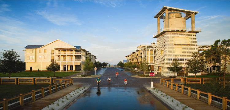 image of WindMark Beach's business district with a family riding on bicycles